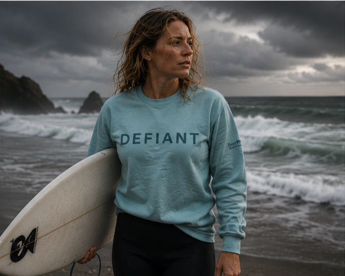 Defiant Sweatshirt on a stormy Pacific Northwest coast surf — queer-owned PNW Pride apparel, front view