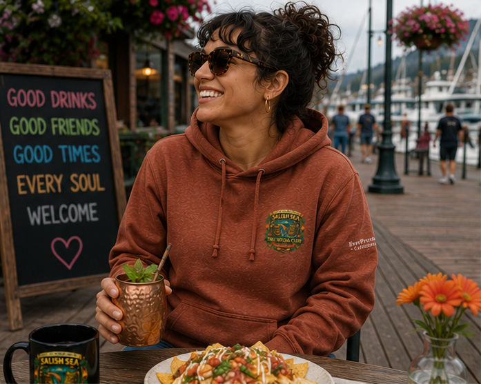 Dockside Divine Hoodie on a Pacific Northwest waterfront brunch deck — queer-owned PNW Pride apparel, front view