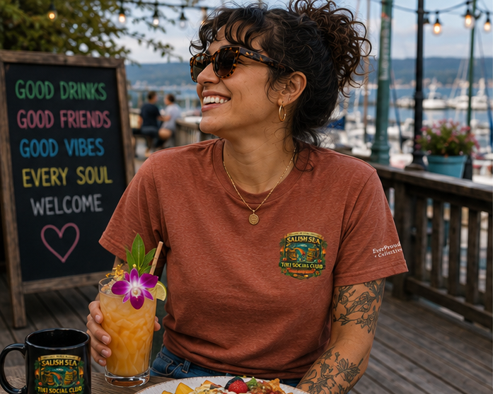 Dockside Divine T-Shirt on a Pacific Northwest waterfront brunch deck — queer-owned PNW Pride apparel, front view