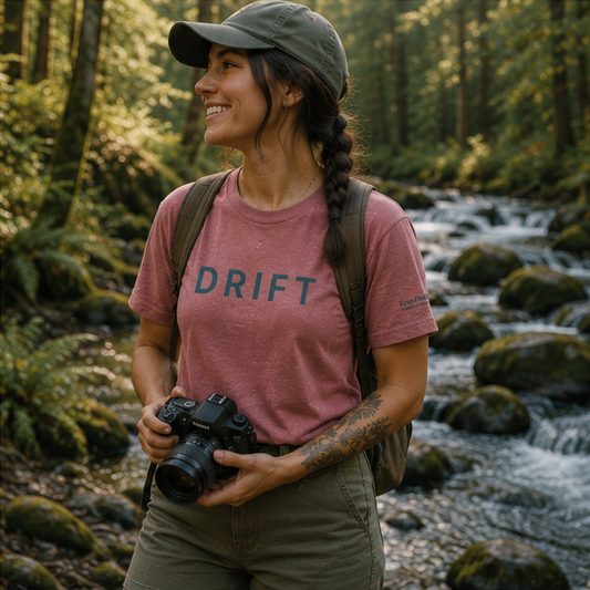 Drift Women's Relaxed T-Shirt at a Pacific Northwest forest photography spot — queer-owned PNW Pride apparel, front view