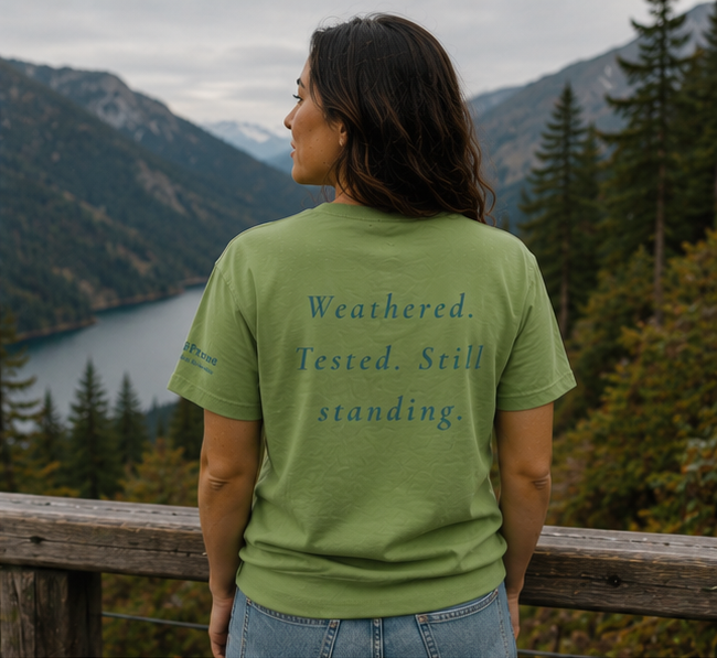 Endure T-Shirt at a misty Pacific Northwest mountain lake — queer-owned PNW Pride apparel, back view with inspirational quote