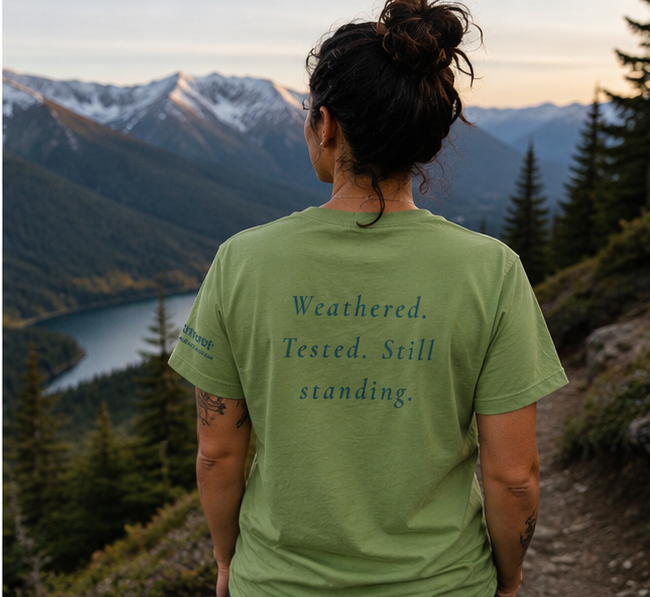 Endure Women's Relaxed T-Shirt at a Pacific Northwest mountain overlook — queer-owned PNW Pride apparel, back view