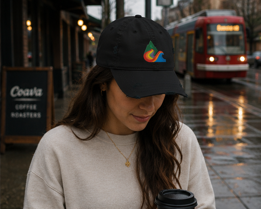 EverProud Logo Minimalist Canvas Cap at a rainy Portland coffee shop — queer-owned PNW Pride apparel, front view