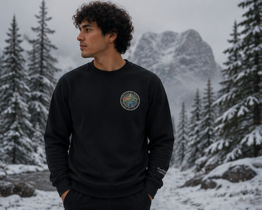 Moved by the Tide Sweatshirt at a snowy Pacific Northwest lakeside in winter — queer-owned PNW Pride apparel, front view