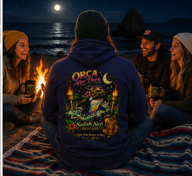 Orca After Dark Hoodie on a Pacific Northwest moonlit beach bonfire — queer-owned PNW Pride apparel, back view