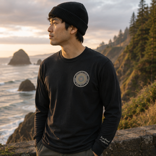 Quiet Rings Long Sleeve Tee on a Pacific Northwest coastal overlook — queer-owned PNW Pride apparel, front view
