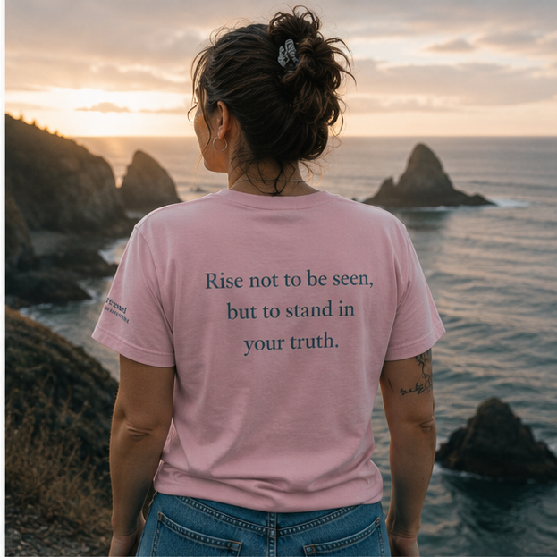 Rise Women's Relaxed T-Shirt on a Pacific Northwest coastal overlook — queer-owned PNW Pride apparel, back view