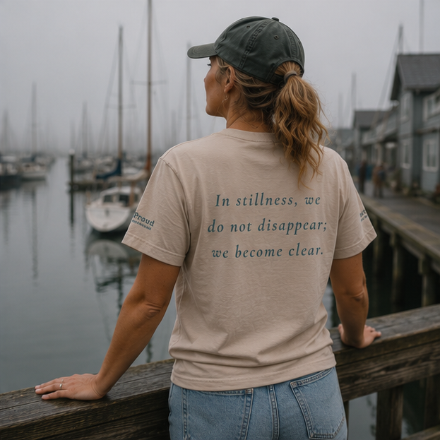 Still Women's Relaxed T-Shirt at a foggy Pacific Northwest marina — queer-owned PNW Pride apparel, back view with inspirational quote