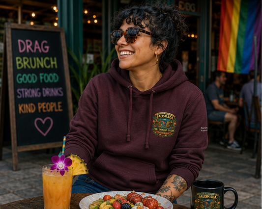 Tiki Drag Brunch Hoodie at a Pacific Northwest café — queer-owned PNW Pride apparel, front view