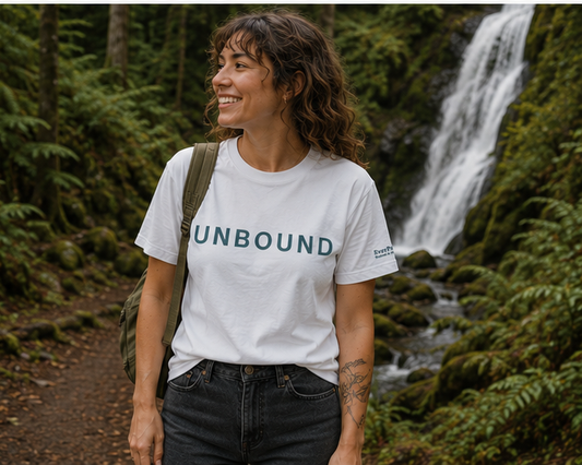 Unbound T-Shirt at a forest waterfall — queer-owned PNW Pride graphic tee, front view