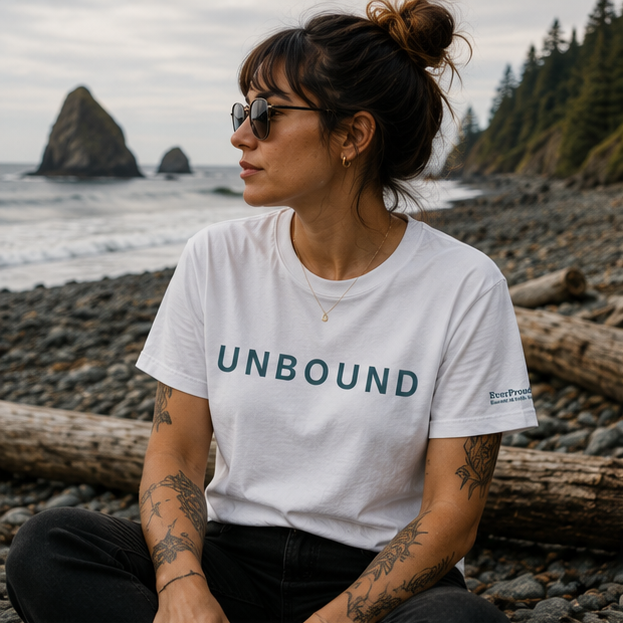 Unbound Women's Relaxed T-Shirt on the rocky Pacific Northwest coast — queer-owned PNW Pride apparel, front view