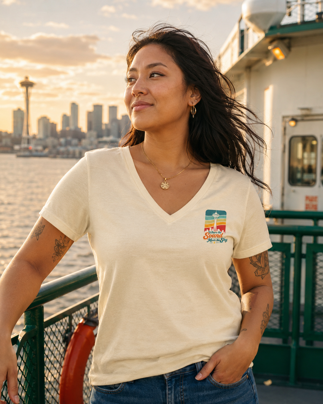 Where the Sound Meets the Sky Women's Relaxed V-Neck T-Shirt at a golden hour ferry deck — queer-owned PNW Pride apparel, front view